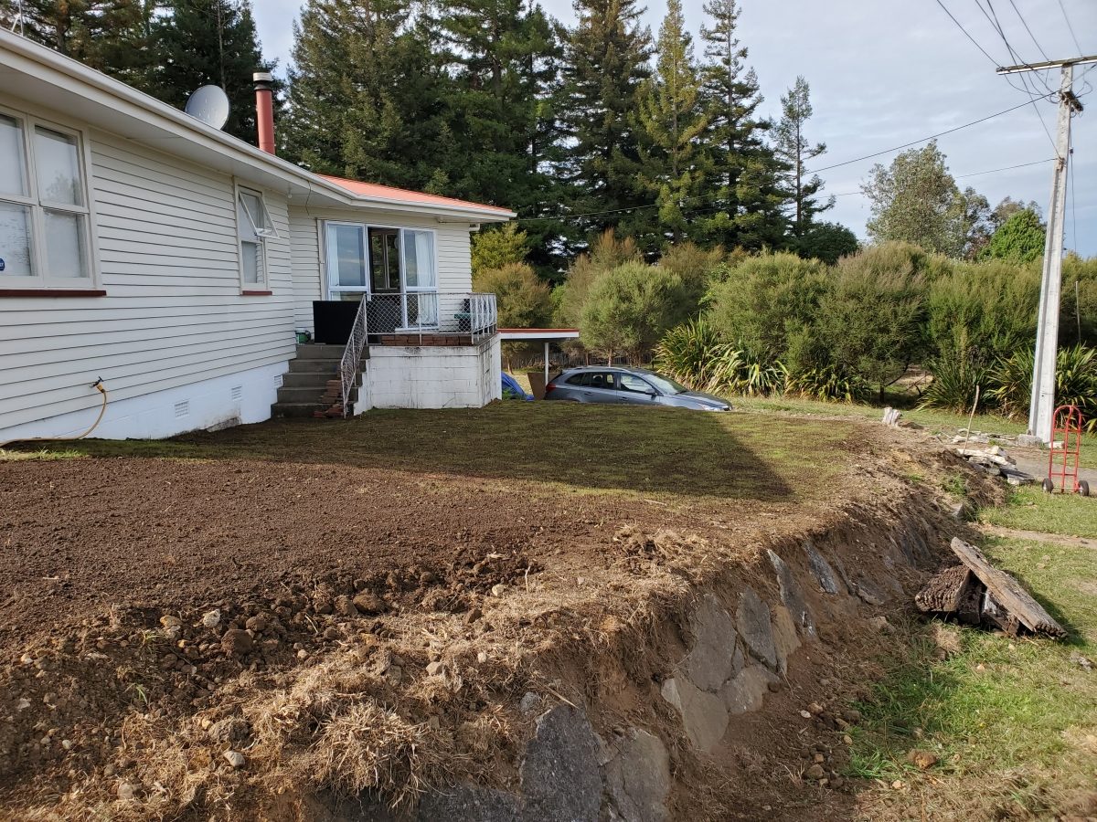 Three-sided section strip-back: top soil, fish pond, foot path, vegetation and a hillside brought down level to the house